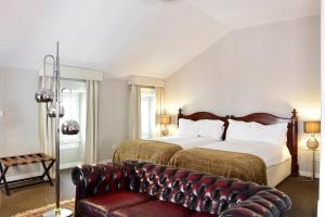 里斯本Palacete Chafariz Del Rei - by Unlock Hotels的酒店客房配有一张床和一张皮沙发