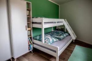 卢布明Ferienwohnung TinyBeach的配有绿色墙壁的客房内的双层床