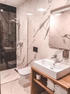 库多瓦-兹德鲁伊La Park Aparthotel的一间带水槽、淋浴和卫生间的浴室