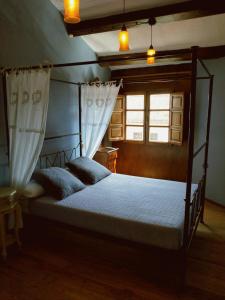 比利亚维西奥萨Las Casas de Isu的一间卧室设有天蓬床和窗户。