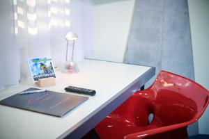 TramelanCIP Hôtel的一张带笔记本电脑和红色椅子的桌子