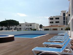 阿尔布费拉Apartamentos Turisticos Monte da Vinha II的游泳池旁的一排躺椅