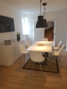 BrackenheimFerienwohnung的一间设有白色桌子和白色椅子的用餐室