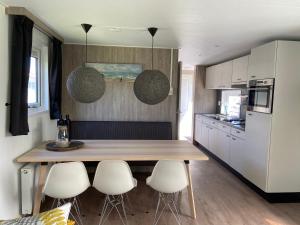 塞罗斯凯尔克olmenduin 33的厨房配有木桌和一些白色家电