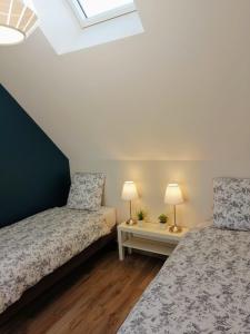 朗布依埃Le petit Mérinos - Rambouillet -的一间卧室设有两张床和两张台灯。