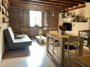 维琴察Vivi Vicenza的厨房以及带桌子和沙发的客厅。