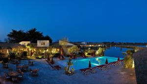 圣马迪拉莫埃斯特尔恩卡马格酒店的一个带椅子和灯光的游泳池的度假酒店