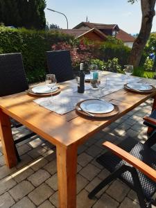Neukirchen vorm WaldStilvolles Apartment "Romantic"的一张木桌,上面放有盘子和酒杯