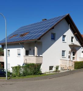OmmersheimFerienwohnung Kempf Mandelbachtal的屋顶上设有太阳能电池板的白色房屋