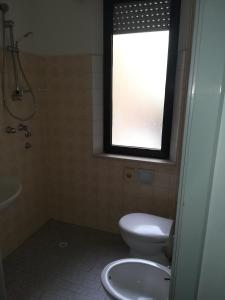 里米尼皮加勒酒店的一间带卫生间、水槽和窗户的浴室
