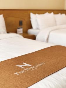 济州市Nohyung Hotel的床上的棕色迎宾垫