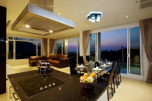卡塔海滩Kata Sea View Villas的厨房以及带桌椅的起居室。