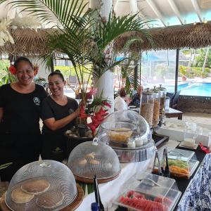 拉罗汤加马努娅海滩度假村的两人站在自助餐前吃点东西