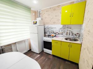 布古拉玛Апартаменты на Сайдашева 3的厨房配有黄色橱柜和白色冰箱