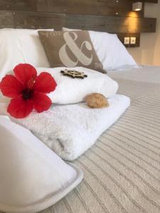 艾丽奇Ammos Luxury Studios的床上的白色毛巾和红花