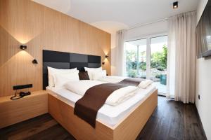 纳莱斯纳尔瑟霍夫花园住宅公寓式酒店的一间卧室设有一张大床和大窗户