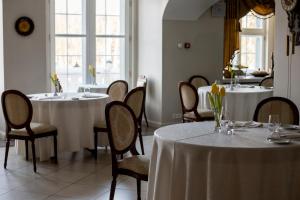 Mālpils马尔皮尔斯庄园酒店的一间带2张桌子和椅子的用餐室