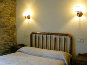 San Martín de OscosCasa del forno的卧室配有一张床,墙上有两盏灯