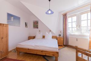 阿伦斯霍普KOJE的一间卧室配有一张带白色床单的床和一扇窗户。