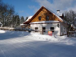 SněžnéPension Klokočí的围栏旁的雪地房子