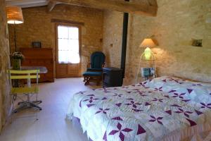 莫扎克和格朗德-卡斯唐Chambres d'hôtes de la Grande Combe的一间卧室配有一张床、一张桌子和一个窗户。