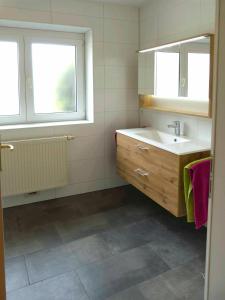 博登斯多夫Ferienwohnung Kern的一间带水槽和镜子的浴室以及两个窗户