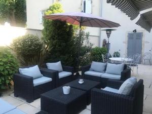 Belleville-en-Beaujolais花园旅馆的户外庭院设有藤椅和遮阳伞。
