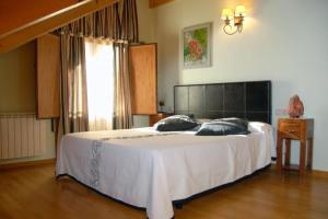 埃斯波特卡萨科洛姆乡村酒店的卧室设有一张白色大床和一扇窗户。