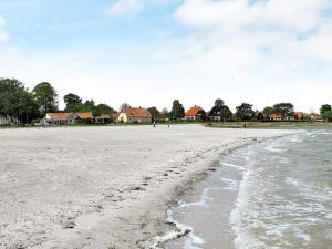 班霍尔姆4 person holiday home in Bandholm的享有海滩美景,设有位于后面的房屋