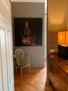 米兰帕蒂尼宾馆的坐在椅子旁边的墙上的女人的画