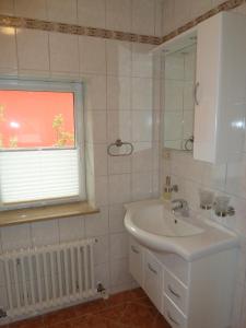 GarzFerien auf Rügen Familie Geist的一间带水槽和镜子的浴室以及窗户。