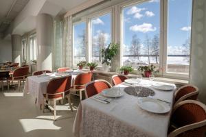 Keminmaa北滩Spa酒店的用餐室配有桌椅和大窗户