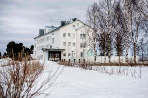 Keminmaa北滩Spa酒店的雪中带围栏的白色房子
