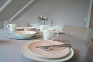 克伦胡森Haus Ruh di ut Wohnung LUV的桌子上摆有盘子和餐具