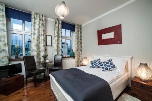 比得哥什格鲁瓦尔德兹齐公寓式民宿的卧室配有一张床、一张书桌和窗户。
