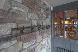 普利布里奇The Pooley Bridge Inn的墙上的石墙,带金属毛巾架