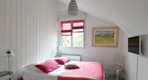 拉波勒Chez Lilette的一间卧室配有一张带粉色床单的床和一扇窗户。