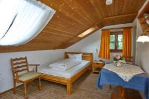 巴特恩多夫爱特布如娜酒店的卧室配有床、椅子和窗户。
