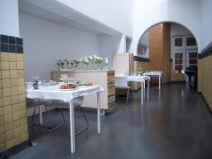 米德尔堡B&B De Kloostertuin的大楼内带白色桌椅的用餐室