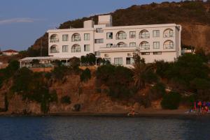 下皮尔戈斯E.J. Pyrgos Bay Hotel的水边小山上的白色大建筑