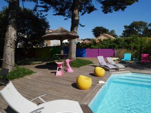 圣布莱温欧申Le Gage location de vacance à la semaine的一个带椅子和桌子的游泳池以及一把遮阳伞