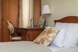 奥古林Heritage Hotel Frankopan的一间卧室配有一张带书桌和枕头的床。