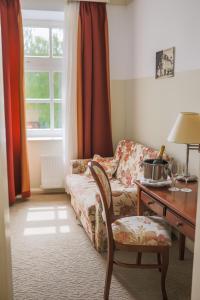 奥古林Heritage Hotel Frankopan的客厅配有沙发、书桌、桌子和椅子