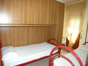 罗索利纳马雷Villa Milviana appartamento的一间小卧室,配有一张床和两把椅子