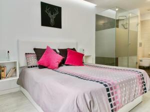 拉克鲁斯The Cool Apartment的卧室配有一张带粉红色枕头的大床