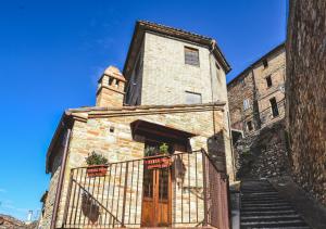 AmandolaVilla Schinoppi的一座古老的石头建筑,设有木门和楼梯