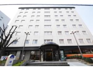 大阪Hotel Shin Osaka / Vacation STAY 81525的白色的建筑,有入口