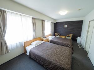 大阪Hotel Shin Osaka / Vacation STAY 81541的酒店客房设有两张床和窗户。