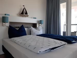 卡珀尔恩Residenz Bollwark Port Olpenitz的一间卧室配有一张带蓝色和白色枕头的床