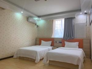 北京7天优品·北京鼓楼后海店的一间卧室设有两张床和窗户。
